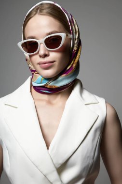 Beautiful young woman in sunglasses and headscarf. fashionable model girl in trendy glasses