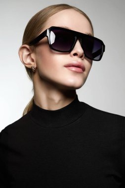 fashion portrait of Beautiful young woman in sunglasses. blond girl in glasses and black wear