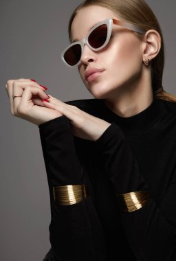 fashion portrait of Beautiful young woman in sunglasses. blond girl in glasses and bracelets