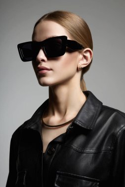 fashion portrait of Beautiful young woman in sunglasses. pretty blond girl in black glasses and leather coat