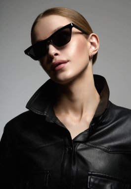 fashion portrait of Beautiful young woman in sunglasses. pretty blond girl in black glasses and leather coat