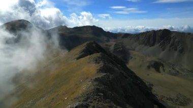 Hava görüntüsü. Yeşil tepelerin üzerinden uçan Andorra dağları çimen ve ağaçlarla kaplı. Dağlarda sisli sabah bulutları. Çevre turizmi ve kırsal eğlence. Yüksek kalite