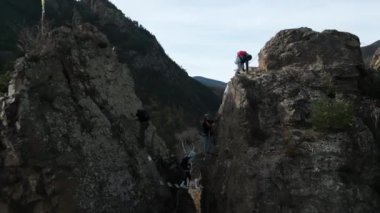 Bir grup dağcı ve güzel manzaralı kayalık duvarlar arasında uçan drone çekimi, güzel bir arka planla kayalıklara tırmanan bir grup dağcı. Büyük Katalonya bayrağıyla