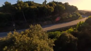Dynamic fpv drone çekimi Motosiklet kovalama güzel gün batımına doğru yılan gibi sürme, Moto sürme altın saat, sürücü beyaz uzun kollu gömlek. Ardından yüksek hızlı fpv drone, 4k görüntü
