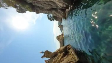 Cinematic vertical fpv shot around group of kayakers on orange kayaks floating, sunny day at Mediterranean Sea in Tossa de Mar, Costa Brava In Spain, Catalonia Aerial view. High quality 4k footage