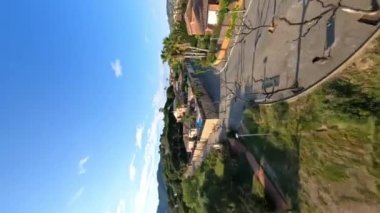 Dynamic vertical fpv view flying above trees in Premia de Dalt area, flying towards to the sea, low and close to green trees. 9 January 2023. High quality 4k footage