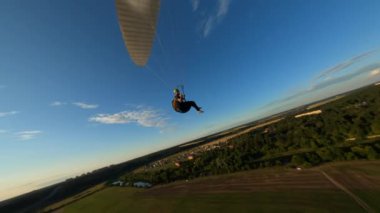 Güzel günbatımında tek başına uçan Paraglider, ormanın üzerinde uçan Fpv İHA 'sı başının üstünde uçuyor, ekstrem sporlar, yamaç paraşütü. Yüksek kalite 4k görüntü