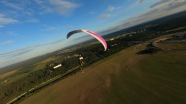 Güzel günbatımında tek başına uçan Paraglider, ormanın üzerinde uçan Fpv İHA 'sı başının üstünde uçuyor, ekstrem sporlar, yamaç paraşütü. Yüksek kalite 4k görüntü