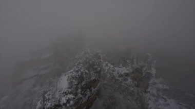 Doğal Sairme Sütunları 'nın FPV drone görüntüleri Georgia' daki karlı kayalara ve ağaçlara yakın bulutlarda uçuyor. Yüksek kalite 4k görüntü