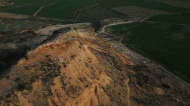 Yeşil tarlalarla çevrili sarı çöl dağları, Mars manzarası, başka bir gezegen..