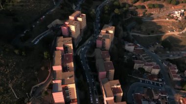 Santa Coloma de Gramanet bölgesinin havadan görünüşü, dağ tarafındaki yerleşim yerleri, arka planda parlak günbatımı, Katalonya, İspanya. Yüksek kalite 4k görüntü