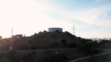 Barcelona 'da Santa Coloma de Gramenet bölgesinin beyaz, yuvarlak su rezervuarının hava manzarası, Parlak gün batımı, Katalonya, İspanya. Yüksek kalite 4k görüntü