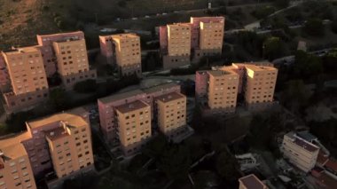 Santa Coloma de Gramanet bölgesinin havadan görünüşü, dağ tarafındaki yerleşim yerleri, arka planda parlak günbatımı, Katalonya, İspanya. Yüksek kalite 4k görüntü
