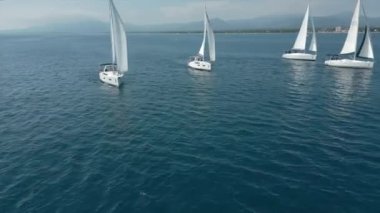 Denizde beyaz yelkenli bir yat. Yatçılık, lüks tatil ve İspanya, Cambrils 'de yelkenli yarışı. Yüksek kalite 4k görüntü