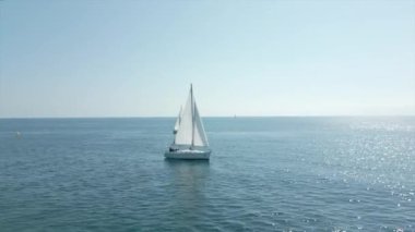 Denizde beyaz yelkenli bir yat. Yatçılık, lüks tatil ve İspanya, Cambrils 'de yelkenli yarışı. Yüksek kalite 4k görüntü