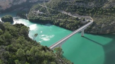 Mavi su gölünün üzerindeki güzel köprünün hava görüntüsü oldukça rüzgarlı bir günde. Corte de Pallas, Valencia, İspanya yüksek kaliteli 4K görüntü.