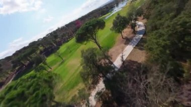 Boş Camiral Golf Sahası ve Sahne Çevresi, Camiral Golf ve Wellness Girona 'nın dinamik FPV drone görüntüsü. Güneşli bir gün, yüksek kaliteli 4K görüntüler.