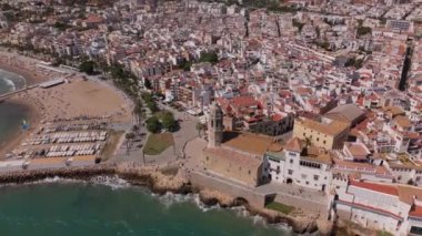 Güneşli bir günde Sitges sahil köyü ve Iglesia de San Bartolome y Santa Tecla 'nın hava manzarası. Yüksek kalite 4k görüntü