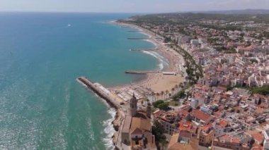Güneşli bir günde Sitges sahil köyü ve Iglesia de San Bartolome y Santa Tecla 'nın hava manzarası. Yüksek kalite 4k görüntü