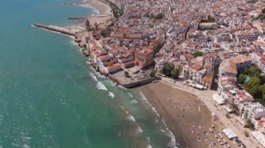 Güneşli bir günde Sitges sahil köyü ve Iglesia de San Bartolome y Santa Tecla 'nın hava manzarası. Yüksek kalite 4k görüntü