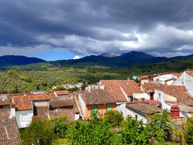 Caceres eyaletindeki Guadalupe 'deki evler bulutlu bir günde dağlarla çevrili.