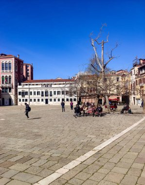 Venedik, İtalya - Nisan 2023. Güneşli bir günde Venedik sokaklarında yürüyen bir turist..
