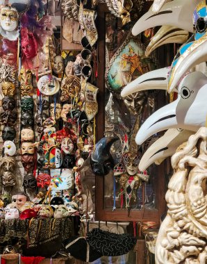 Venedik, İtalya - Nisan 2023. Venedik caddesinde güneşli bir günde hediyelik eşya satan karnaval maskecisi.