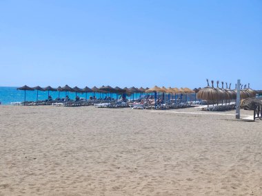 Torremolinos, İspanya - Mayıs 2022. Akdeniz 'de kumsalda güneşlenen insanlar. Yazın İspanyol turistik kasabası..