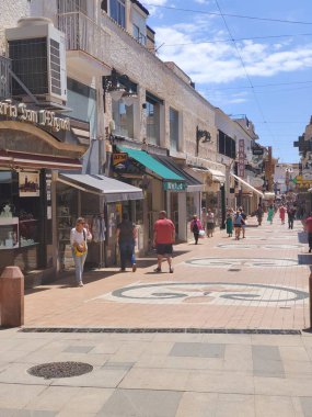Torremolinos, İspanya - Mayıs 2022. İnsanlar yaz aylarında sokakta kahve dükkanının yanında yürürler. İspanyol turistik kasabası..