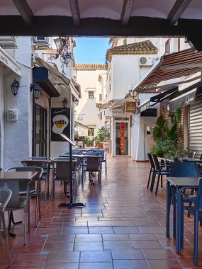 Torremolinos, İspanya - Mayıs 2022. İnsanlar yazın her iki tarafta da hediyelik eşya dükkanıyla sokakta yürüyorlar. İspanyol turistik kasabası..