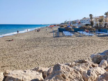 Torremolinos, İspanya - Mayıs 2022. Akdeniz 'de kumsalda güneşlenen insanlar. Yazın İspanyol turistik kasabası..