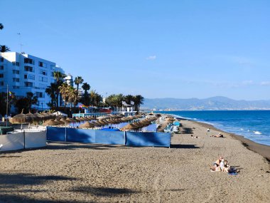 Torremolinos, İspanya - Mayıs 2022. Akdeniz 'de kumsalda güneşlenen insanlar. Yazın İspanyol turistik kasabası..