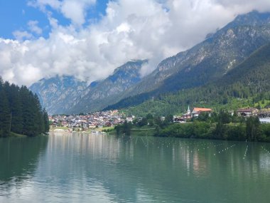 Güneşli bir günde İtalya 'nın kuzeyinde arka planda evleri olan göl.