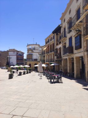 San Lorenzo del Escorial, Madrid, İspanya - Mayıs 2022. Güneşli bir günde İspanya 'nın merkezindeki ortaçağ kasabasının sokaklarında yürüyen turistler