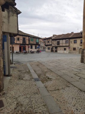 Segovia, İspanya - Mayıs 2022. İspanya 'nın merkezinde, ortaçağ şehrinin merkez meydanındaki insanlar bulutlu bir günde. Arka planda bir kahve dükkanı görebilirsiniz.