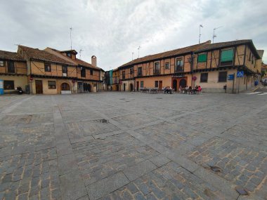 Segovia, İspanya - Mayıs 2022. İspanya 'nın merkezinde, ortaçağ şehrinin merkez meydanındaki insanlar bulutlu bir günde. Arka planda bir kahve dükkanı görebilirsiniz.