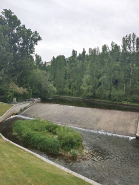 Segovia şehrindeki nehir bulutlu bir günde doğa ile çevrilidir.