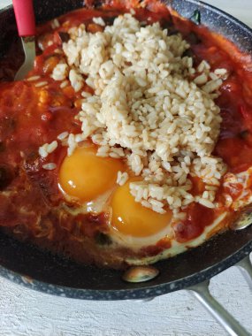 Tavada kızarmış yumurta ve domates soslu pilav.