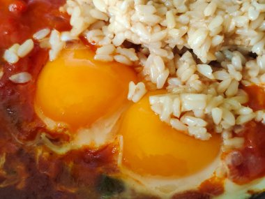 Tavada kızarmış yumurta ve domates soslu pilav.