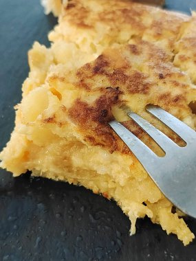 Tabakta çatalla servis edilen patates omleti.