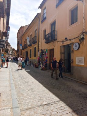 Segovia, İspanya... 22 Mayıs 2023. Segovia 'nın merkezindeki caddelerde turistler. Bulutlu bir günde şehirdeki tarihi mimariyi ve yaşam tarzını görebilirsiniz..