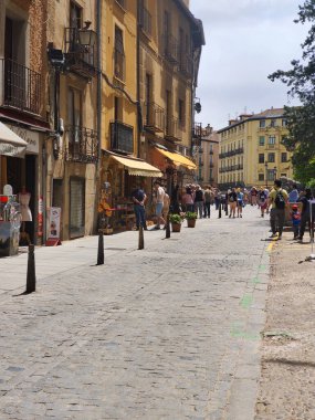 Segovia, İspanya... 22 Mayıs 2023. Segovia 'nın merkezindeki caddelerde turistler. Bulutlu bir günde şehirdeki tarihi mimariyi ve yaşam tarzını görebilirsiniz..