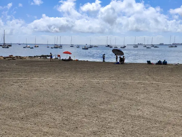 San Javier, Murcia, İspanya - 10 Haziran 2022. La Manga del Mar Menor sahilinde palmiye ağaçlı turistler. Akdeniz 'de güneşli bir gün..