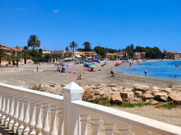 San Javier, Murcia, İspanya - 10 Haziran 2022. La Manga del Mar Menor sahilinde palmiye ağaçlı turistler. Akdeniz 'de güneşli bir gün..