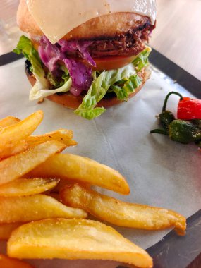 Tabakta patates kızartmasıyla servis edilen hamburgerci.