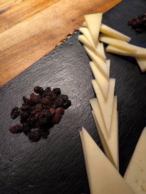 Siyah tabakta servis edilen peynir parçaları.