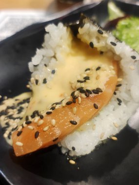 Dilimlenmiş suşi tabakta servis edilir.