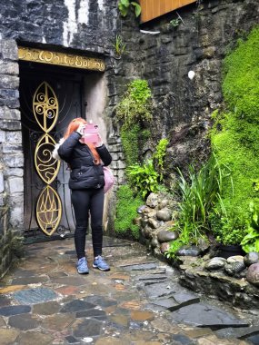 Glastonbury, Birleşik Krallık-Eylül, 9, 2024. Bulutlu bir günde Kadeh Kuyusu Bahçelerinde yürüyen hacılar. İngiltere 'nin güneyindeki Glastonbury' deki ağaçları ve çiçekleri görebilirsiniz..