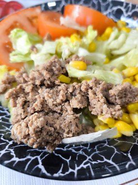 Tabakta servis edilen domates ve avokadoyla ton balığı salatası.