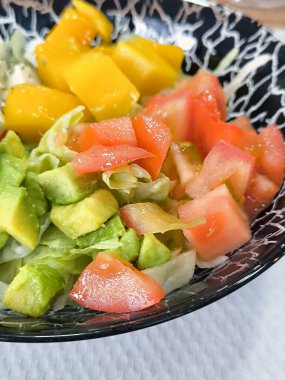 Tabakta servis edilen domates ve avokadoyla ton balığı salatası.